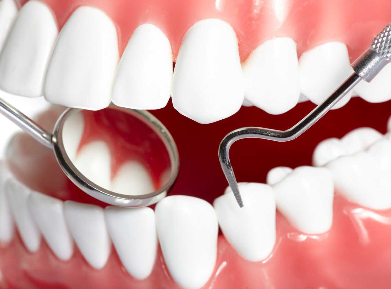 Healthy human teeth and a dentist mouth mirror